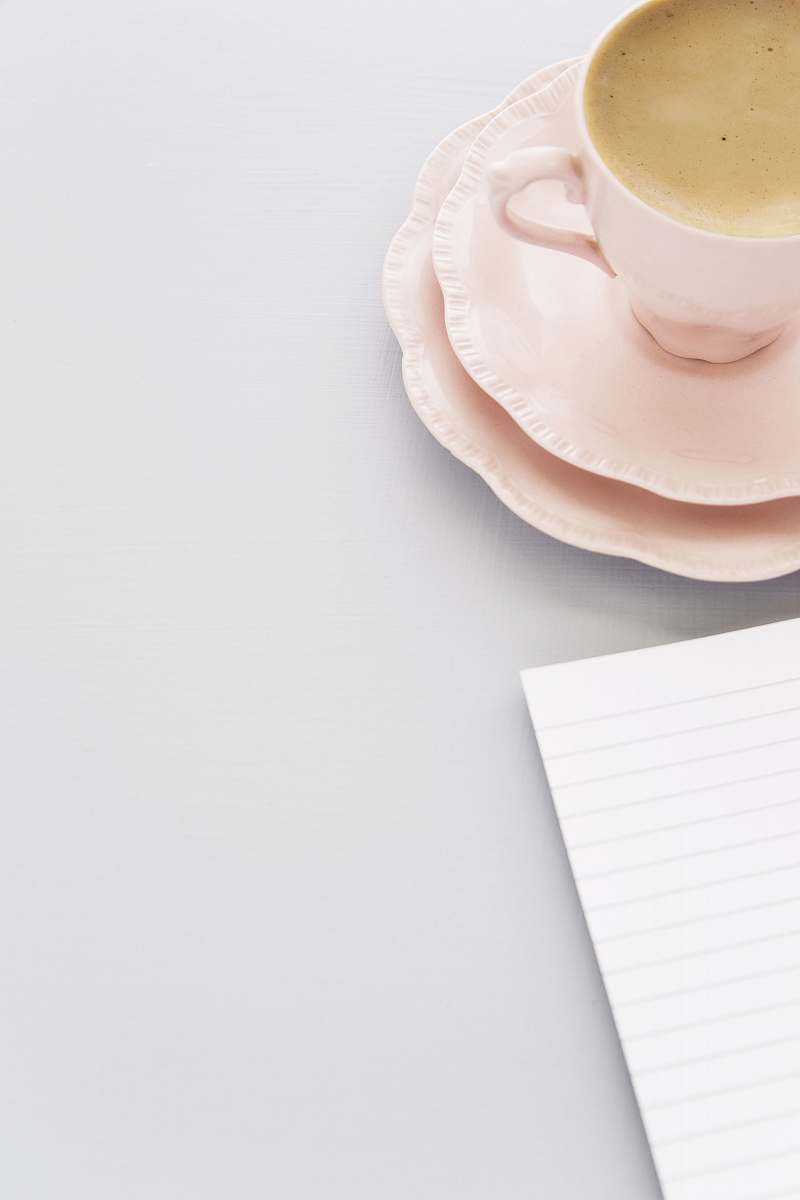 coffee cup black-lined paper beside pink ceramic cup and saucer pottery